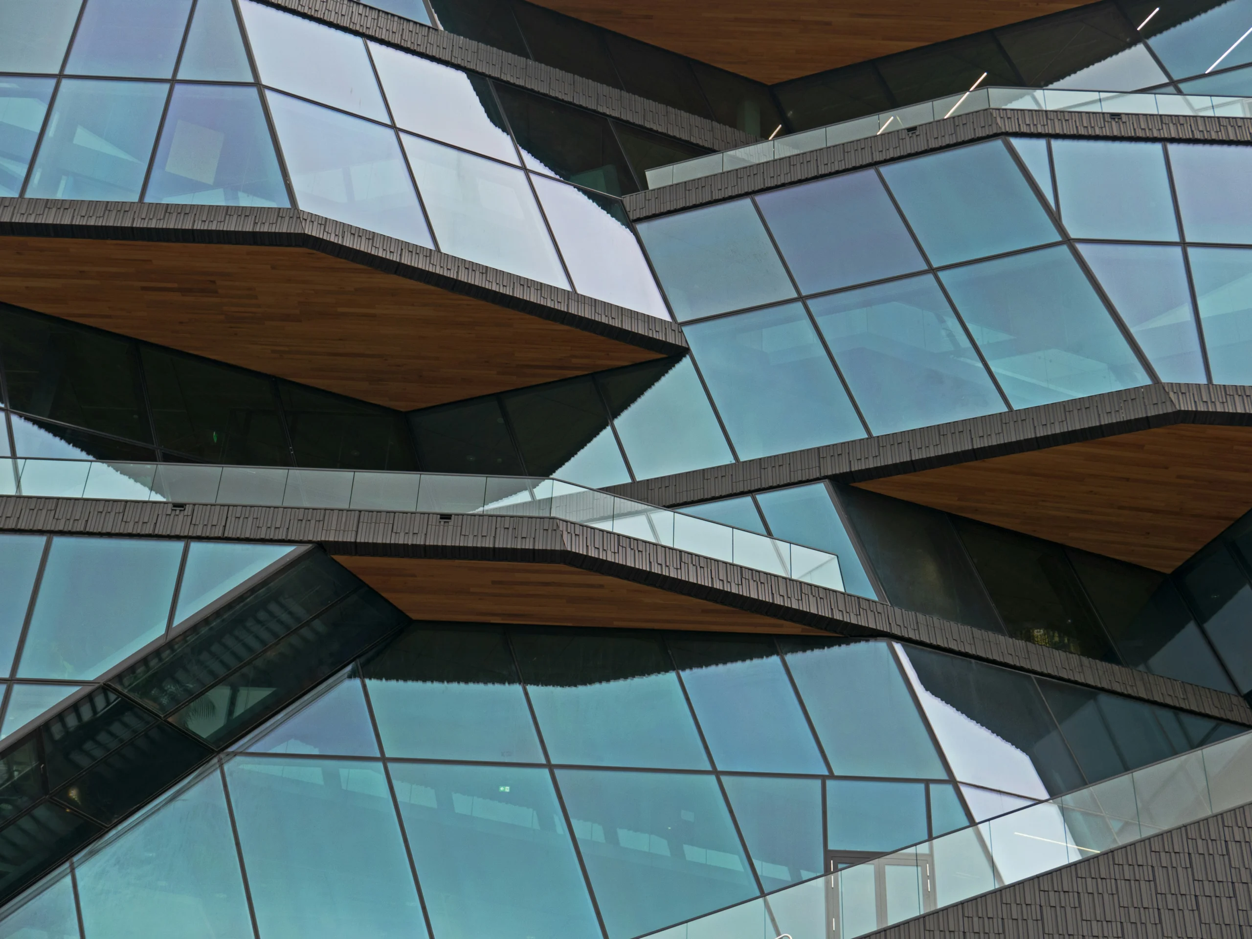 Institutional Opacity — Photo by Fons Heijnsbroek (Unsplash) Close up of a modern building facade with repetitive glass windows creating a sense of impenetrable institutional complexity.
